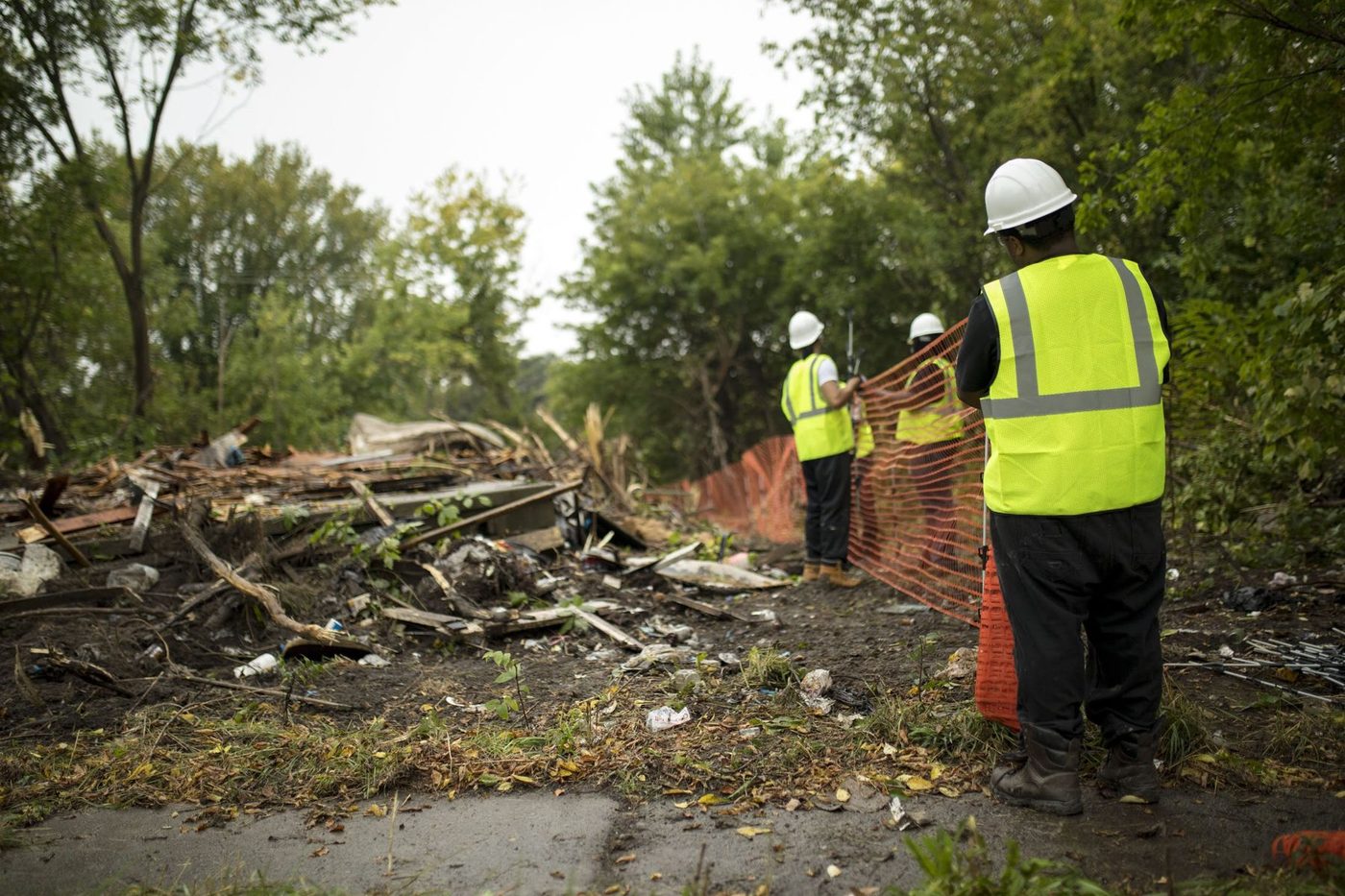 Gayanga laborers setting site fencing on a Detroit neighborhood demolition