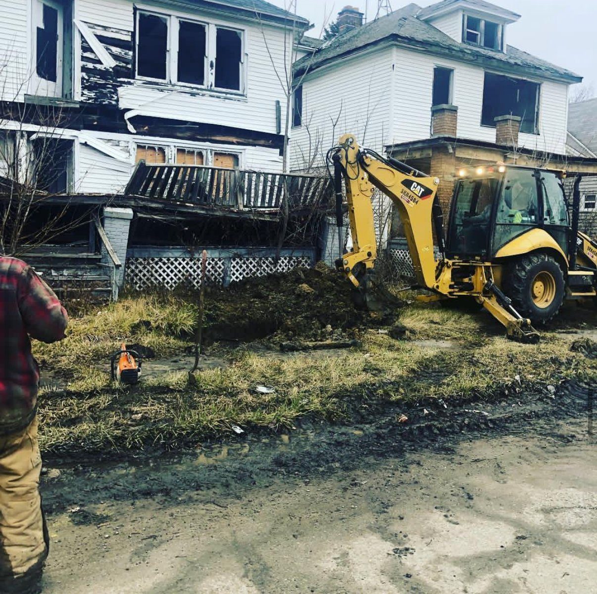 A Gayanga operator on a CAT backhoe digging up a water service line under the City's water services contract, 2018