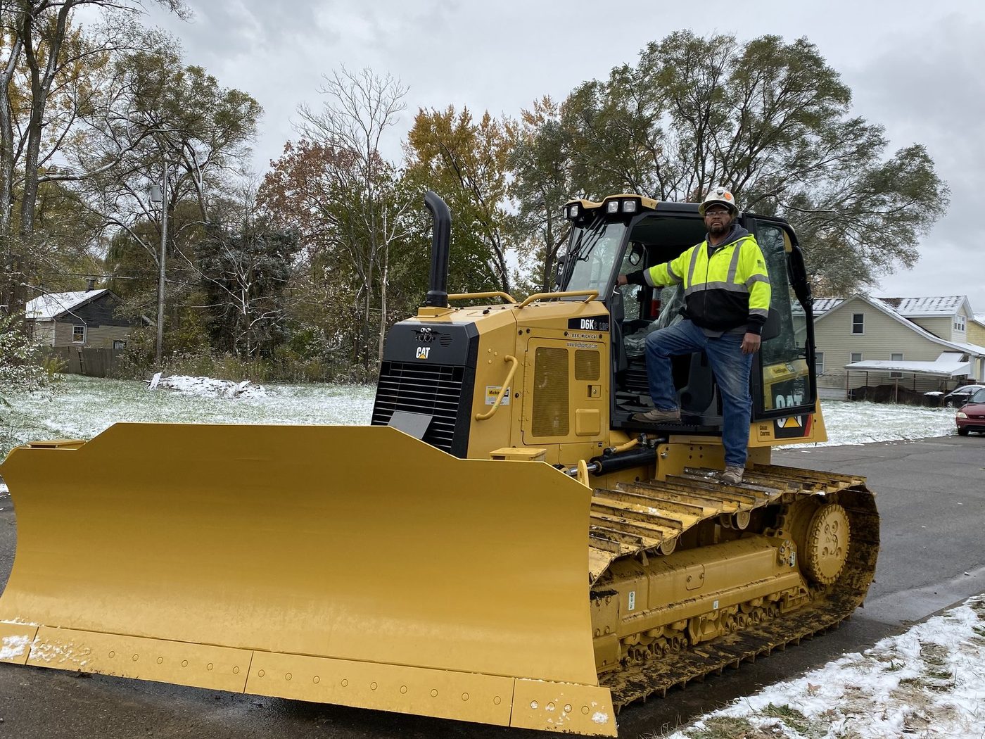 A Gayanga operator in the cab of a brand-new CAT dozer on a Detroit street