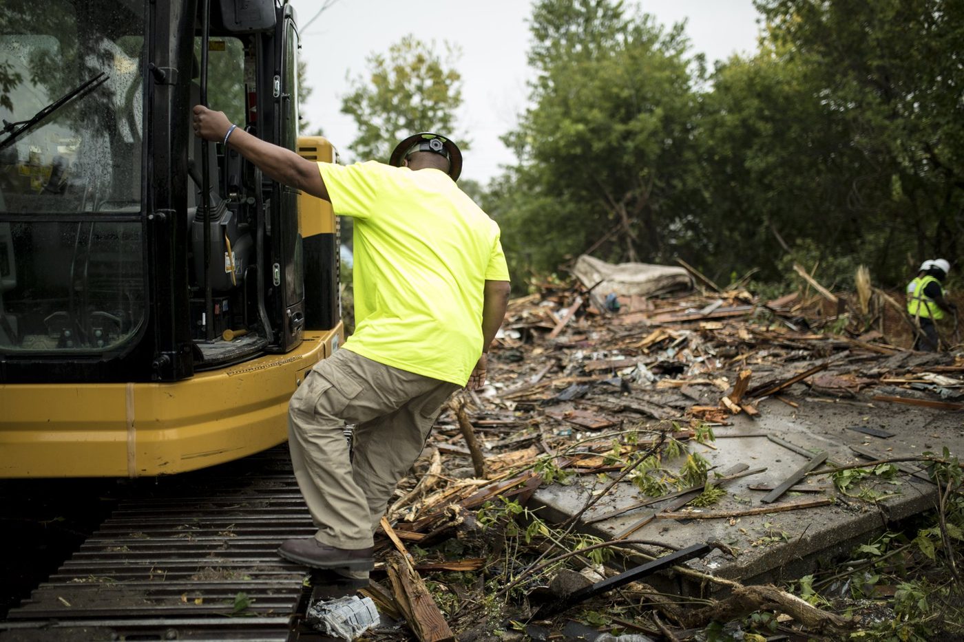 A Gayanga operator climbing into the cab of a CAT excavator, 2017